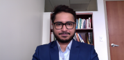 portrait in office space with book lined shelf in the background