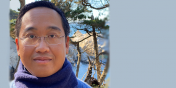 Outdoor shot of Min with snowy firs and mountains in the background
