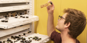 Cole looking at a vial of invertebrate specimens drawn from a cabinet of such vials