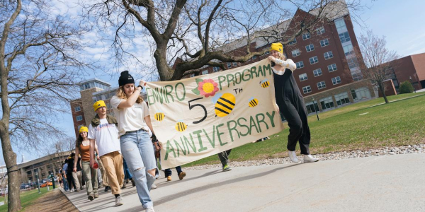 Students walking with 50th Anniversary banner