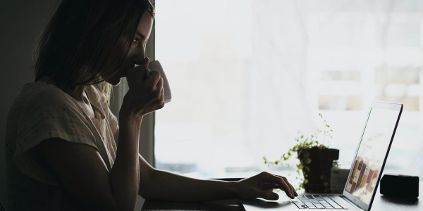 Lady at a laptop drinking coffee