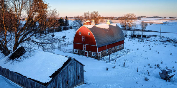 A farm in winter with a sunset. 