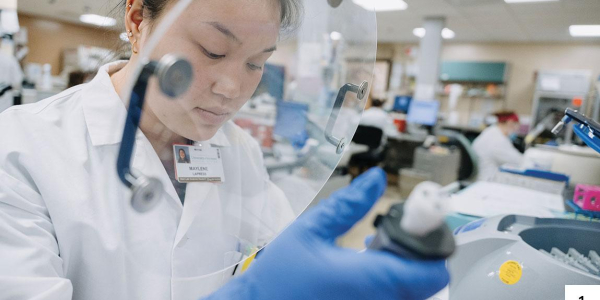 A woman in a lab uses a pipette