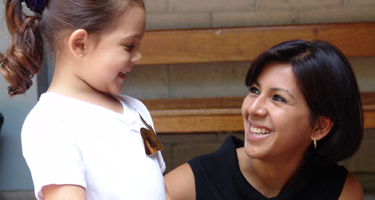 woman helping child, both smiling